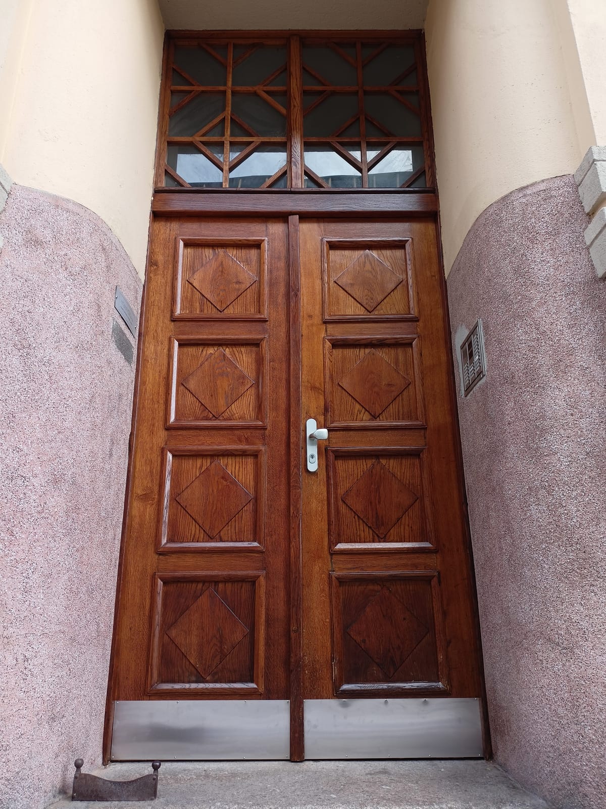 Dubové vchodové dveře s kosočtvercovými kazetami a geometrickou mříží v nadsvětlíku